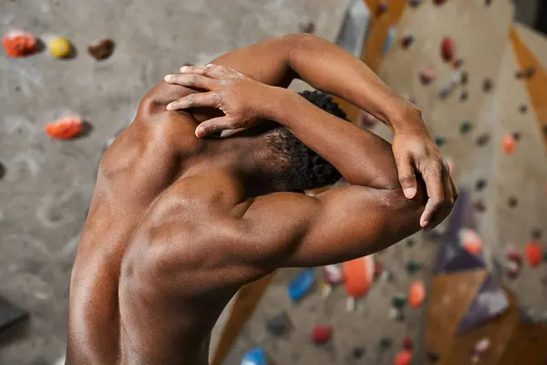 Rückenansicht eines fitten afrikanisch-amerikanischen Mannes, der oben ohne posiert, die Hände hinter dem Kopf, leicht zur Seite gelehnt — Stockfoto