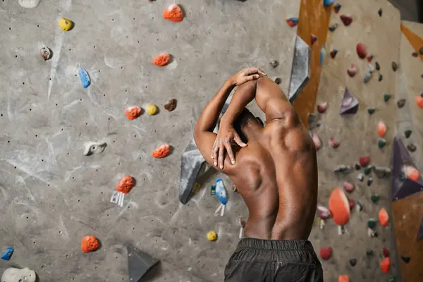 Back view of sporty shirtless african american man slightly bending his body and flexing muscles — Stock Photo