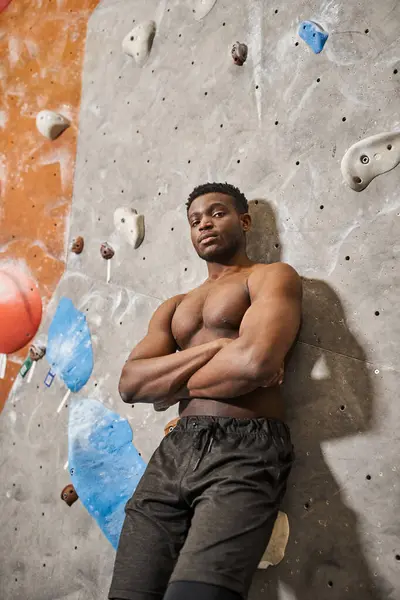 Sporty good looking african american man posing topless next to climbing wall with arms crossed — Stock Photo