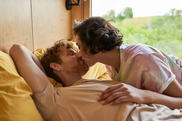 Romanticismo e tenerezza, donna asiatica e rossa uomo baciarsi in camera da letto con vista sulla foresta — Foto stock