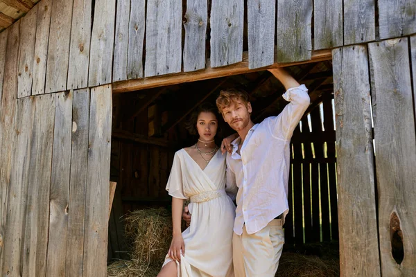 Newlyweds in countryside, pretty asian bride in white dress standing with groom in wooden barn — Stock Photo