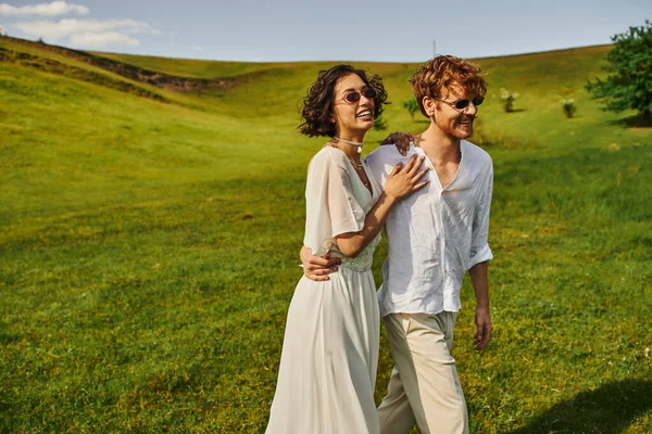 Appena sposati coppia, felice sposa asiatica in abito da sposa a piedi con lo sposo in campo, campagna — Foto stock