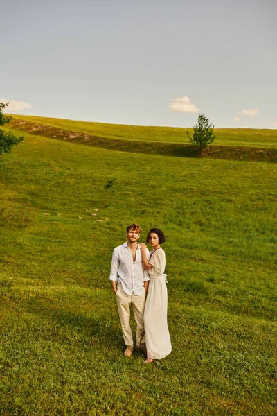 Gerade verheiratete multikulturelle Paar steht zusammen in der grünen Wiese, malerische und ruhige Landschaft — Stockfoto