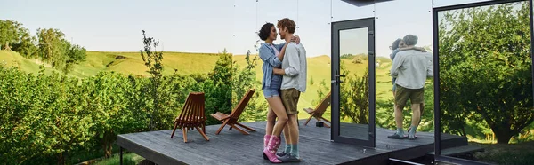 Paar umarmt sich auf Veranda in der Nähe von modernem Glashaus, romantisches Date auf dem Land, Banner — Stockfoto