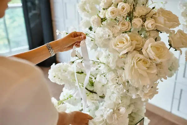 Vista cortada de florista com fita perto de composição floral branca no salão de eventos, decoração do banquete — Fotografia de Stock