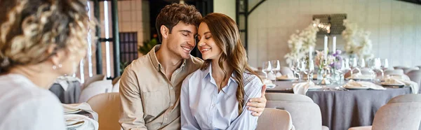 Couple joyeux amoureux souriant avec les yeux fermés près organisateur de banquet dans la salle de mariage, bannière — Photo de stock