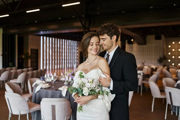 Entzücktes Paar in eleganter Hochzeitskleidung lächelt in die Kamera im modernen Bankettsaal, Banner — Stockfoto