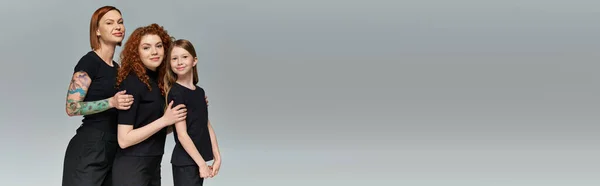 Weibliche Generationen Konzept, glückliche rothaarige Frauen und Kind in passender Kleidung umarmen sich auf grau, Banner — Stockfoto