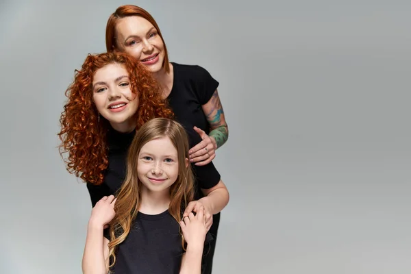 Conceito de gerações, família deliciosa com cabelo vermelho posando em trajes correspondentes em fundo cinza — Fotografia de Stock