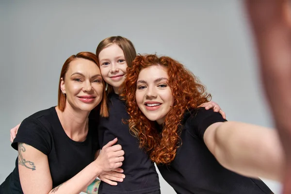 Concetto di generazioni femminili, donne rosse che prendono selfie con ragazza lentigginosa su sfondo grigio — Foto stock