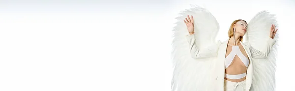 Beleza divina, mulher em traje de luz anjo alado de pé com os olhos fechados no branco, bandeira — Fotografia de Stock