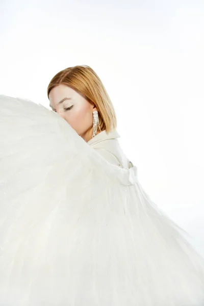 Donna con aura angelica volto oscuro con ali divine su sfondo bianco, purezza e serenità — Foto stock