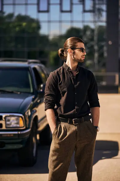 Accrocheur jeune homme avec des accessoires posant à côté de sa voiture avec les mains dans les poches, chauffeur sexy — Photo de stock