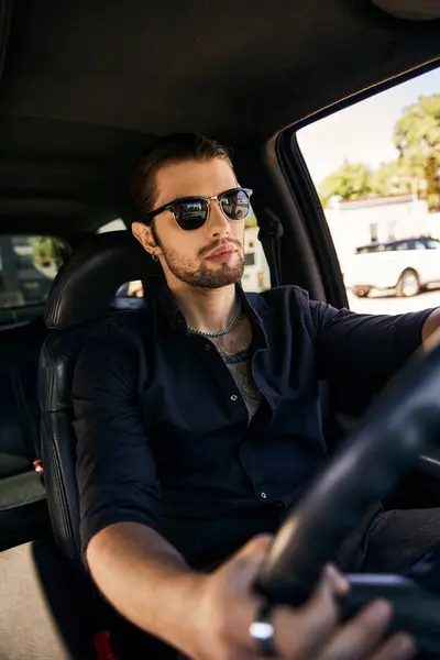Plan vertical de bel homme élégant avec des lunettes de soleil assis derrière le volant, concept de mode — Photo de stock