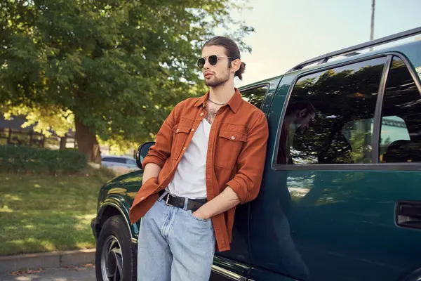 Modelo masculino de boa aparência com olhar dapper posando ao lado de seu carro com as mãos nos bolsos, motorista sexy — Fotografia de Stock