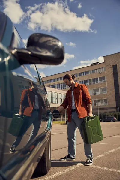 Вертикальний знімок хорошої сексуальної чоловічої моделі в стильному одязі для заправки свого автомобіля бензином — стокове фото