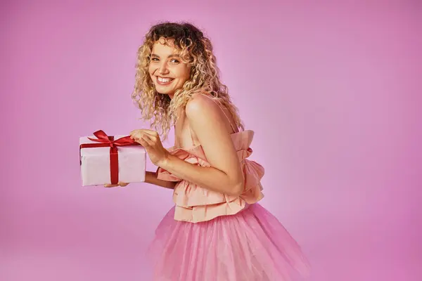 Lovely beautiful woman in tooth fairy costume holding present and looking happily at camera — Stock Photo