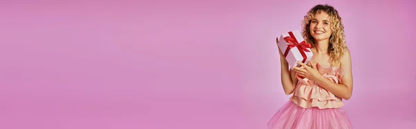 Belle jolie femme en costume rose de fée des dents regardant la caméra et tenant cadeau, bannière — Photo de stock