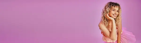 Gioiosa bella donna in costume rosa sorridente sinceramente alla macchina fotografica con mano fino a faccia, banner — Foto stock