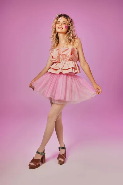 Gorgeous lovely woman in pink tooth fairy costume with face stickers posing on pink backdrop — Stock Photo