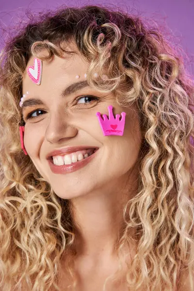 Portrait of pretty blonde woman with curly hair and face stickers smiling sincerely at camera — Stock Photo