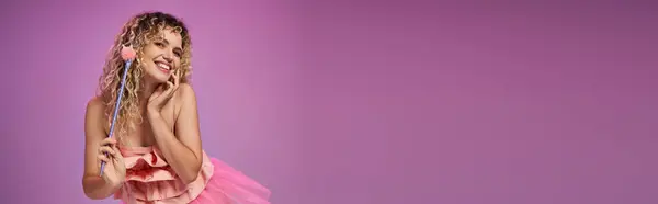 Красива зубна фея в яскраво-рожевому вбранні, що тримає чарівну паличку і посміхається на камеру, банер — стокове фото