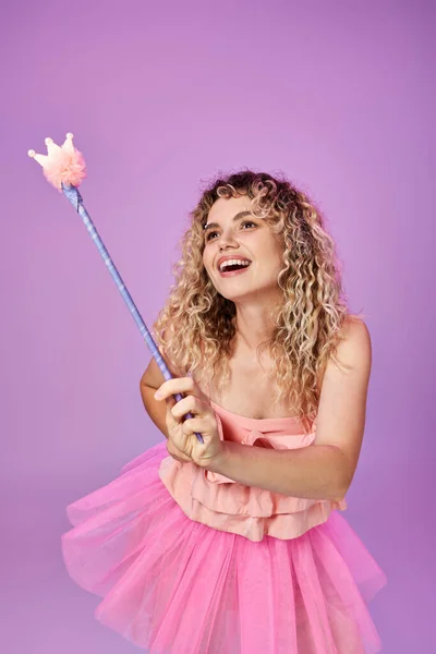 Schöne Frau im rosafarbenen Kleid zaubert mit Zauberstab und schaut weg, Zahnfee Konzept — Stockfoto