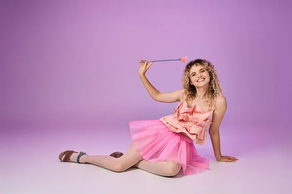 Прекрасная радостная женщина в розовой одежде с волшебной палочкой позируя на розовом фоне, Зубная Фея концепции — стоковое фото