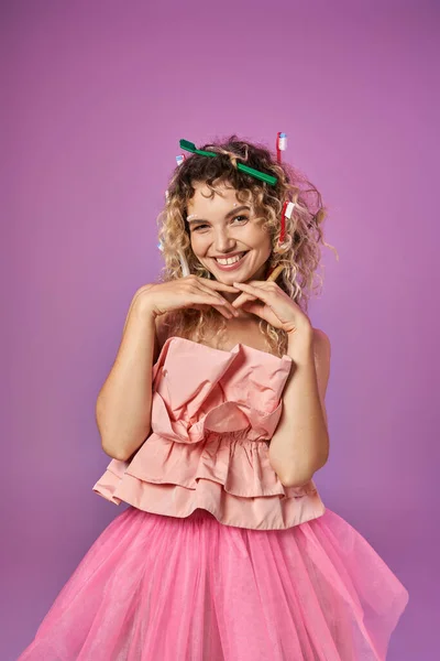 Smiling woman in pink outfit with hands raised to face posing on pink backdrop, tooth fairy concept — Stock Photo