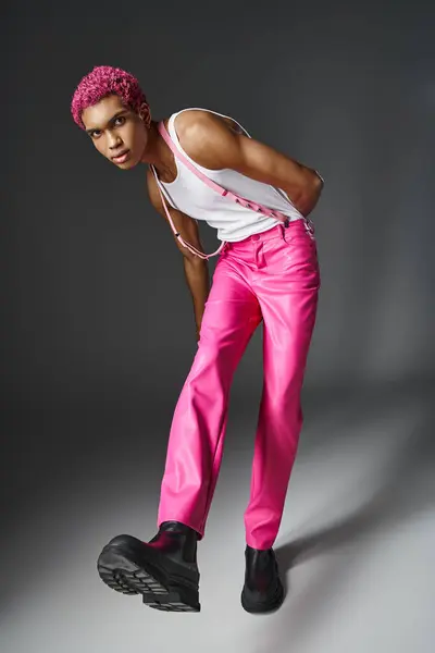 Stylisches afrikanisch-amerikanisches männliches Model mit rosafarbenen lockigen Haaren mit Blick auf Kamera, Mode und Stil — Stockfoto