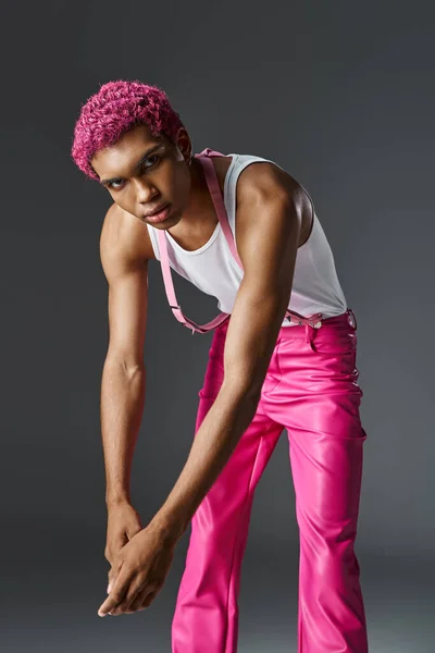 Trendy male model with pink hair slightly leaning forward and looking at camera, fashion and style — Stock Photo