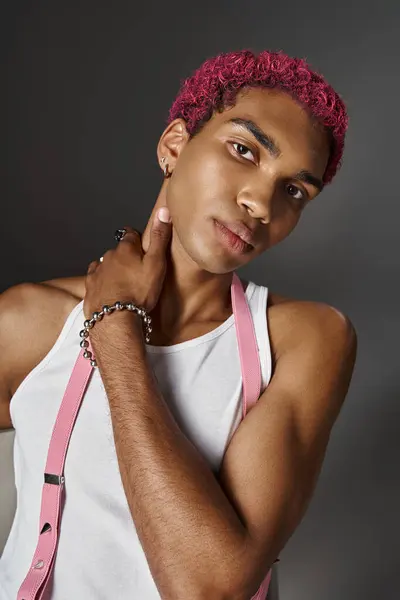 Portrait de l'homme aux cheveux roses en tenue vibrante voguish avec la main sur son cou, concept de mode — Photo de stock