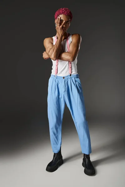 Young pink haired male model posing with slightly crossed arms with hand on face, fashion concept — Stock Photo