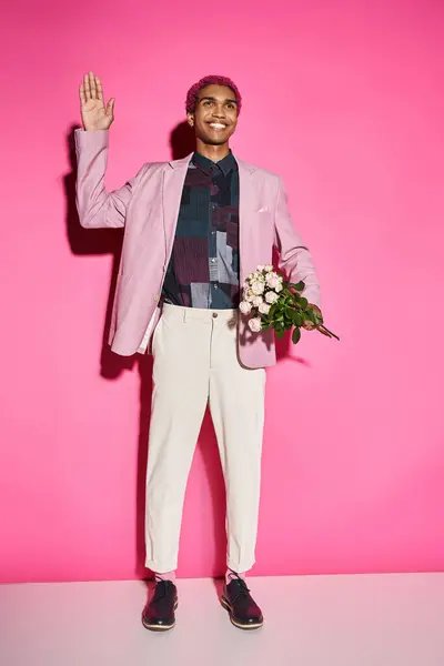 Cheerful man in stylish attire acting unnaturally waving and holding rose bouquet, doll like — Stock Photo