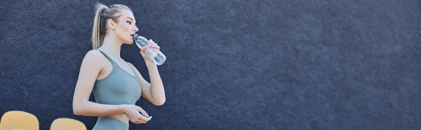 Спортсменка-блондинка в активной питьевой воде и стоящая возле стульев стадиона, баннер — стоковое фото