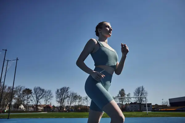 Vista a basso angolo di sportswoman in abbigliamento attivo correre all'aperto, motivazione e concetto di sport — Foto stock