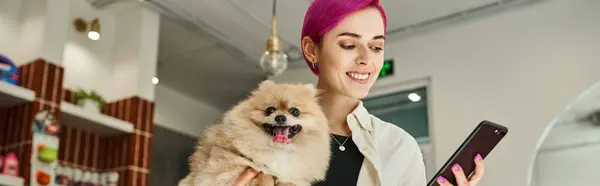 Happy woman with funny pomeranian spits looking at smartphone in lobby of pet hotel, banner — Stock Photo