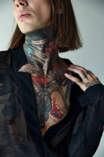 Ausgeschnittene Ansicht des hübschen männlichen Modells mit Tätowierungen im schwarzen transparenten Hemd, Modekonzept — Stockfoto
