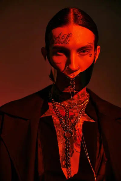 Tiro vertical de hombre joven con estilo en la máscara atada futurista con tatuajes en la cara, concepto de moda - foto de stock