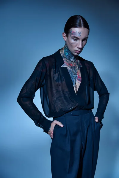 Schöner stilvoller Mann in verführerischem transparentem Hemd mit Tätowierungen mit Händen in Taschen, Mode — Stockfoto