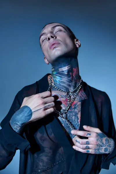 Hombre elegante guapo en camisa transparente y accesorios de cadena posando con los ojos cerrados, moda - foto de stock