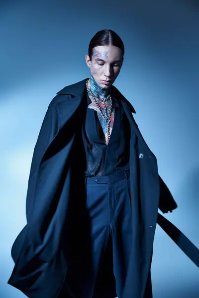 Вертикальний знімок привабливого молодого чоловіка в стильному чорному вбранні позує і дивиться вниз, концепція моди — стокове фото