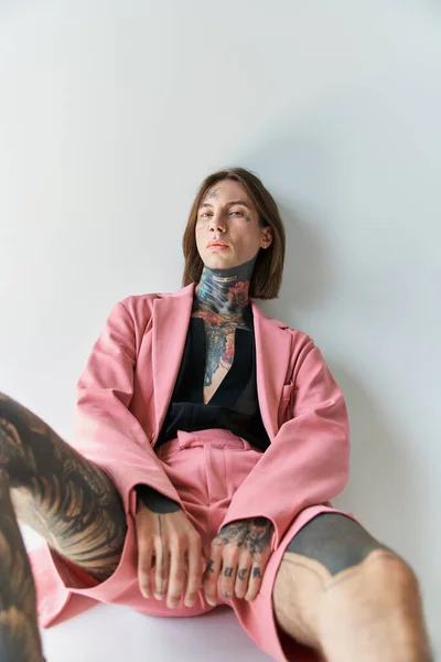 Scatto verticale di giovane elegante in giacca rosa e pantaloncini che guardano la macchina fotografica, concetto di moda — Foto stock
