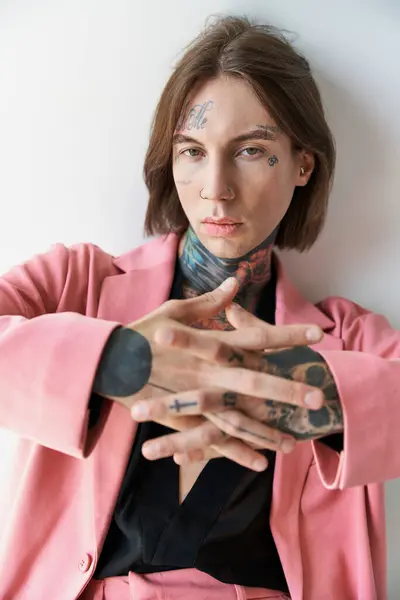 Scatto verticale di giovane in blazer rosa che guarda la macchina fotografica con le mani davanti alla macchina fotografica, moda — Foto stock