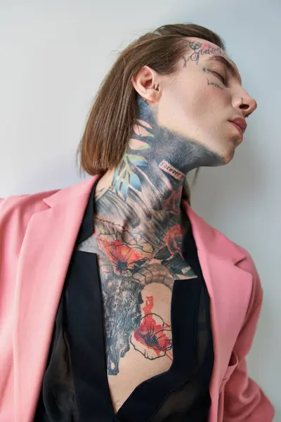 Verführerischer junger Mann im rosafarbenen Blazer und transparentem schwarzen Hemd, der posiert und wegschaut, Mode — Stockfoto