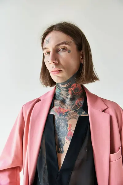 Вертикальный снимок сексуального молодого человека с татуировками в стильной одежде, смотрящего в камеру, концепция моды — стоковое фото