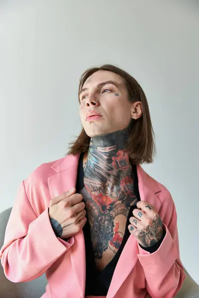 Tiro vertical de joven sexy con tatuajes tocando el cuello de su elegante chaqueta rosa, la moda - foto de stock