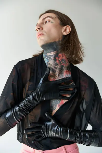 Hombre sexy de buen aspecto en camisa transparente y guantes de cuero con estilo mirando hacia otro lado, concepto de moda - foto de stock