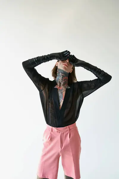 Colpo verticale di giovane uomo sexy in pantaloncini rosa e camicia nera trasparente con le mani sul viso — Foto stock