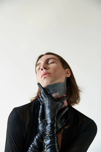 Colpo verticale di seducente uomo in camicia trasparente con mani in guanti di pelle sul collo, moda — Foto stock